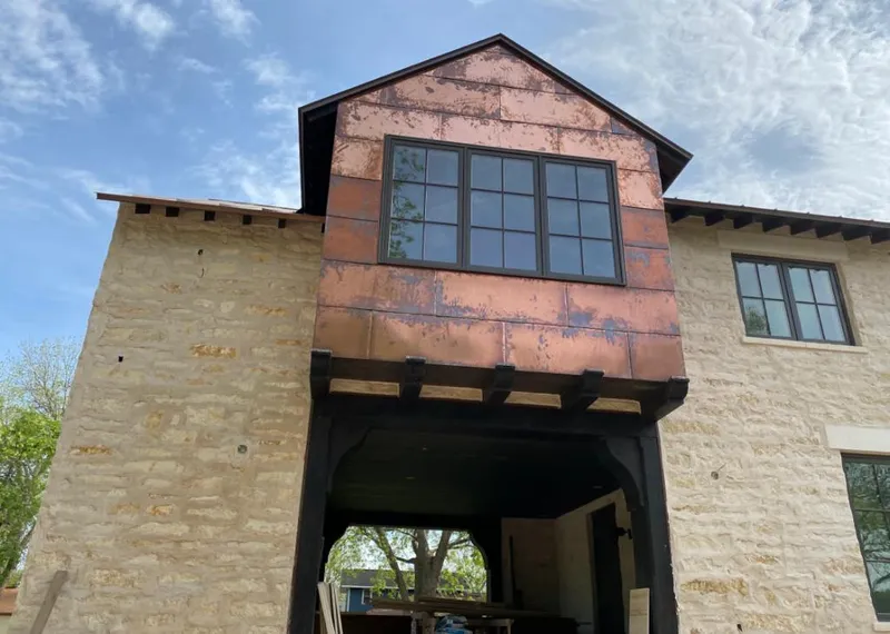 Copper metal panel facade on a stone building for Skylight Installation in Fuquay